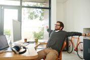 Mann auf Bürostuhl streckt sich Mann auf Bürostuhl streckt sich